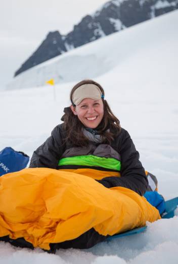 One of our guests smiles for a photo in theie bivvy bag as they wake up after overnight camping in Antarctica.