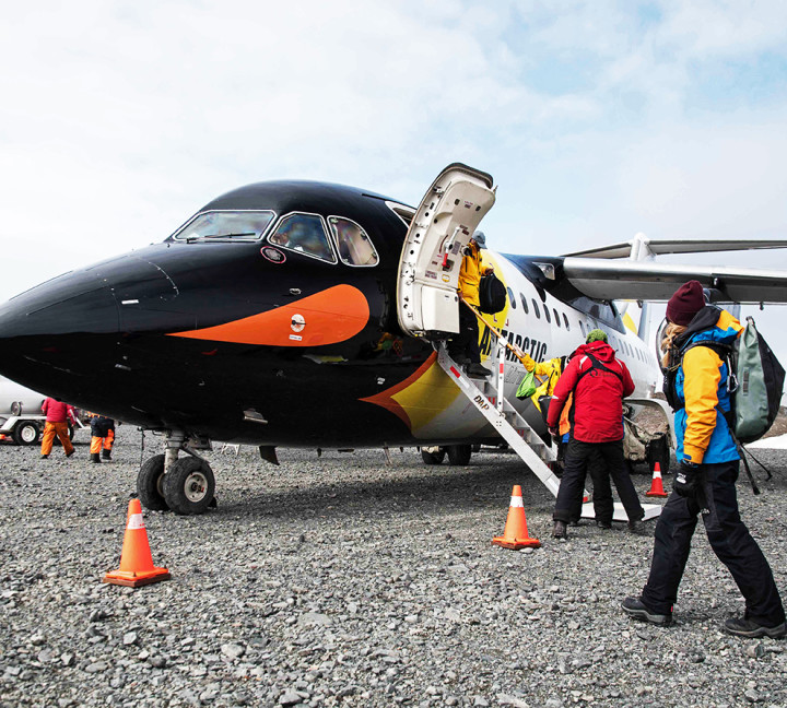A guest sets foot in Antarctica after disembarking a their penguin-paint job plane on one of our Fly/Cruise voyages.