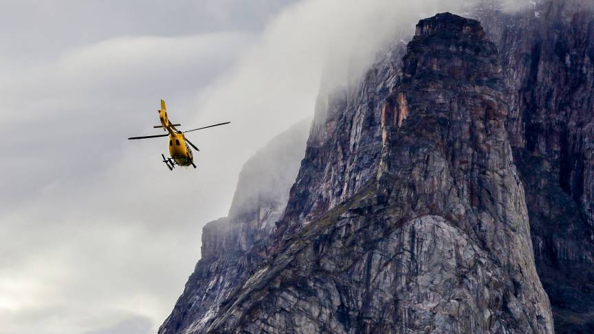 Helicopter flying next to a cliff