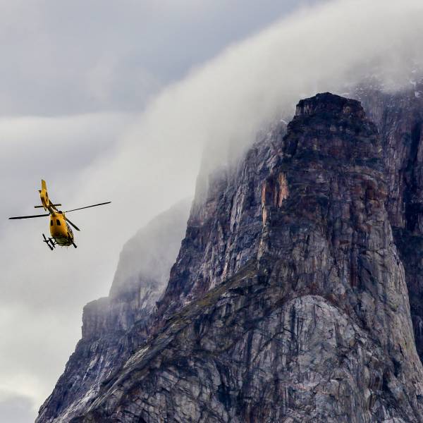 Helicopter flying next to a cliff