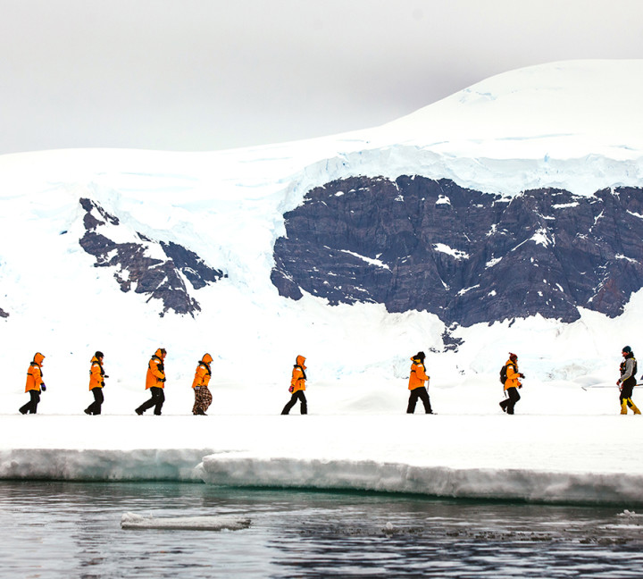 Guests walk in a single file as they explore their surroundings during a sea ice "landing".