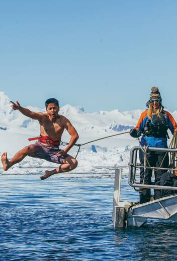 A guest jumps off the gangway (with a safety harness) into Antarctic waters during the Polar Plunge.