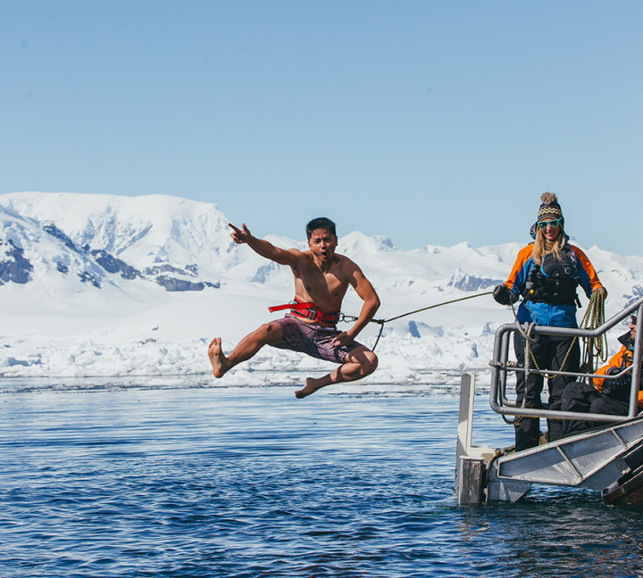A guest jumps off the gangway (with a safety harness) into Antarctic waters during the Polar Plunge.