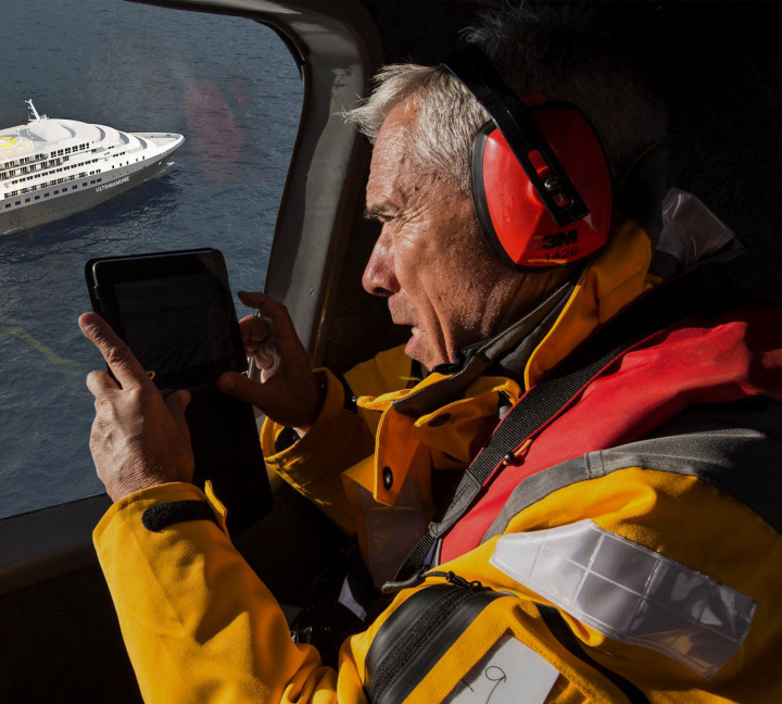 A guest takes photos of the ship Ultramarine while helicopter flightseeing.