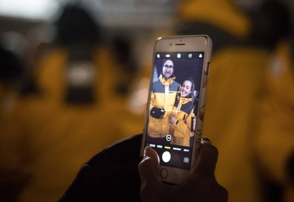 Screen of mobile phone showing selfie photograph of male and female traveler on a polar expedition cruise ship