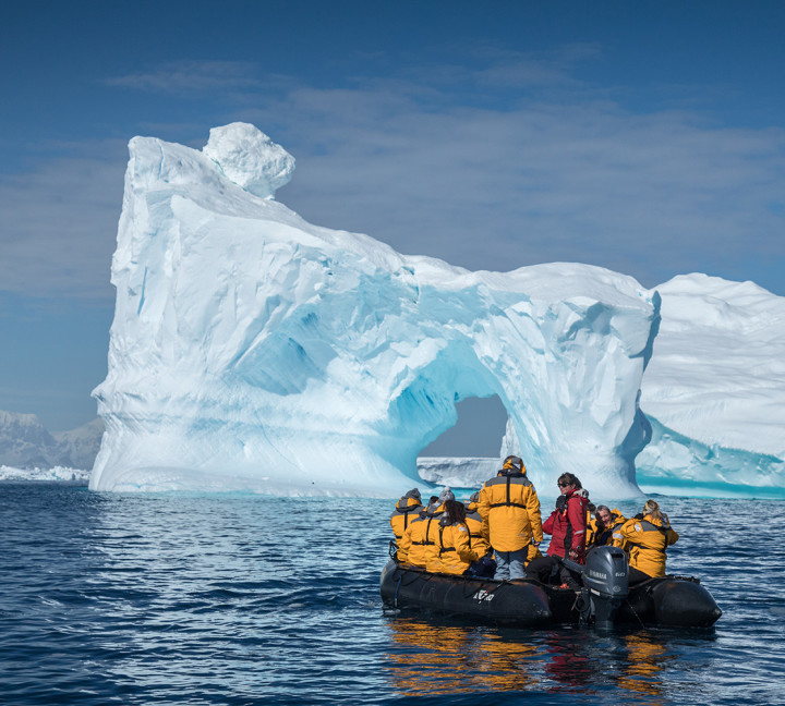 Eleven guests and an Expedition Guide witness a massive iceberg as they stop at a safe distance to capture photographs